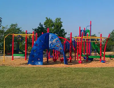 a playground with colorful play equipment with Cadillac Ranch in the background