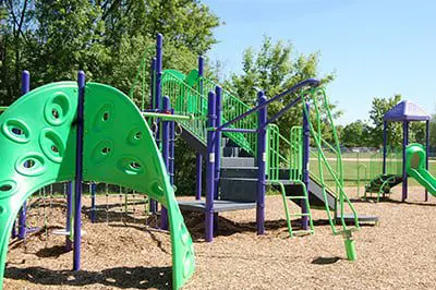 a playground with green and purple slides