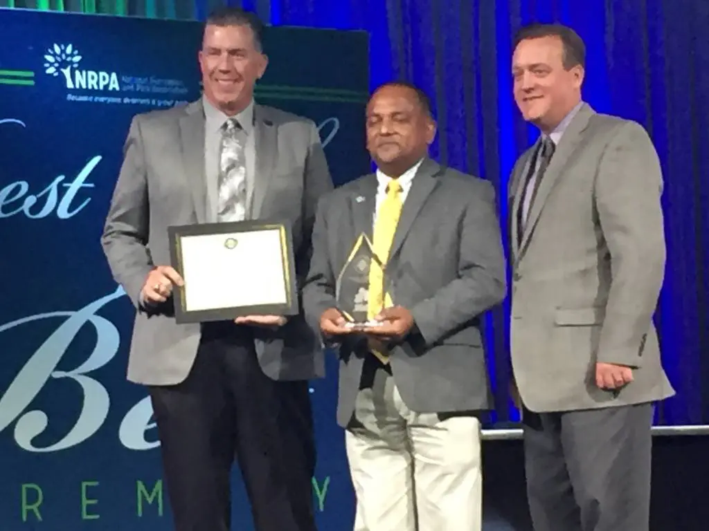 a group of men standing on a stage holding a plaque