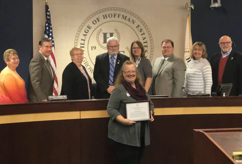 a group of people standing in front of a desk
