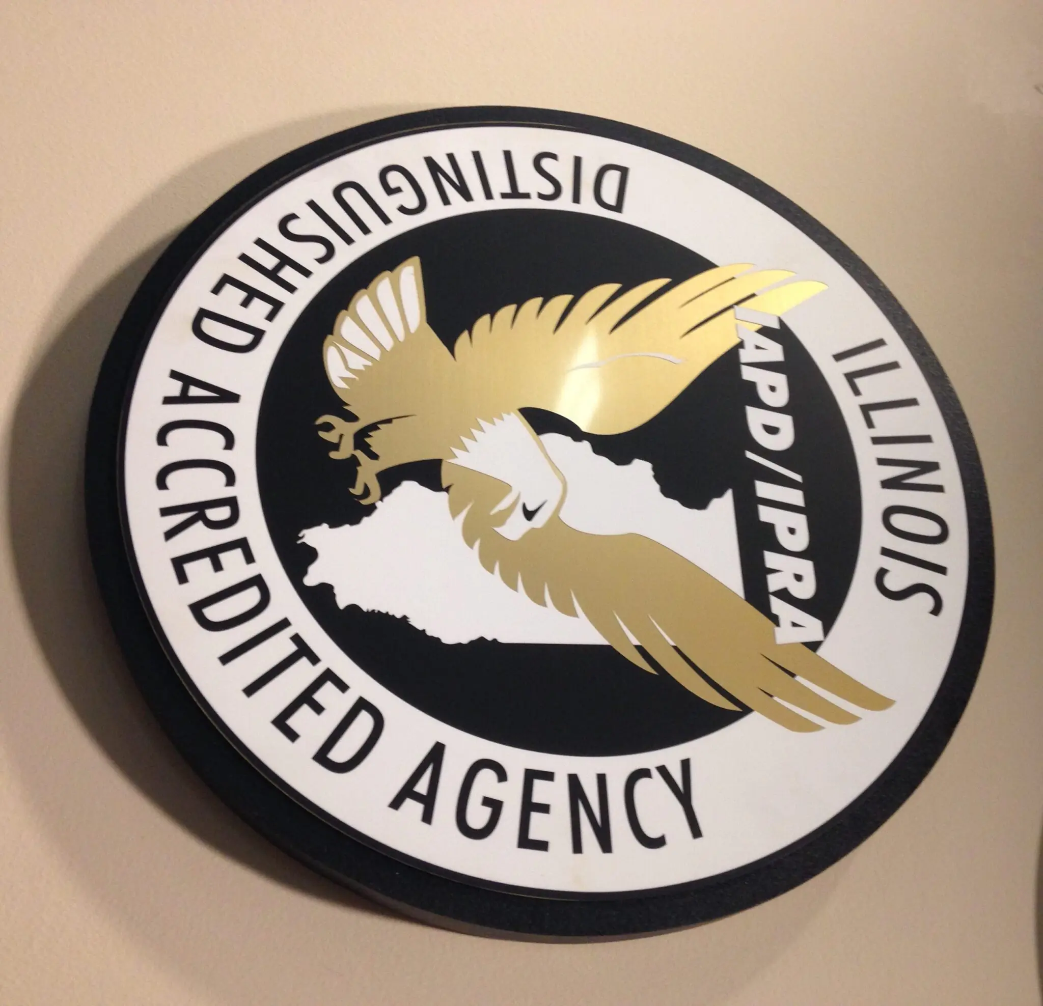 a black and white circular sign with a gold eagle and white text