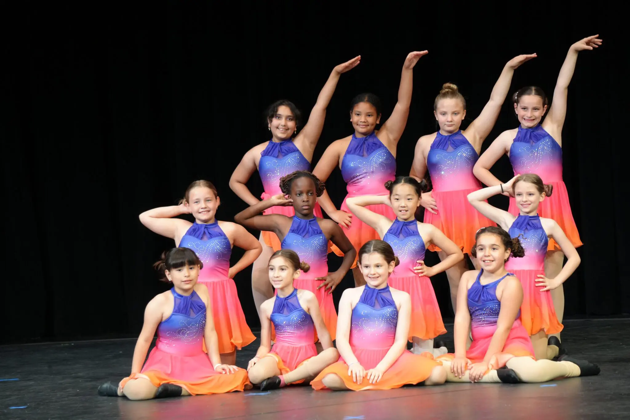 a group of young childs in colorful dresses posing for a photo