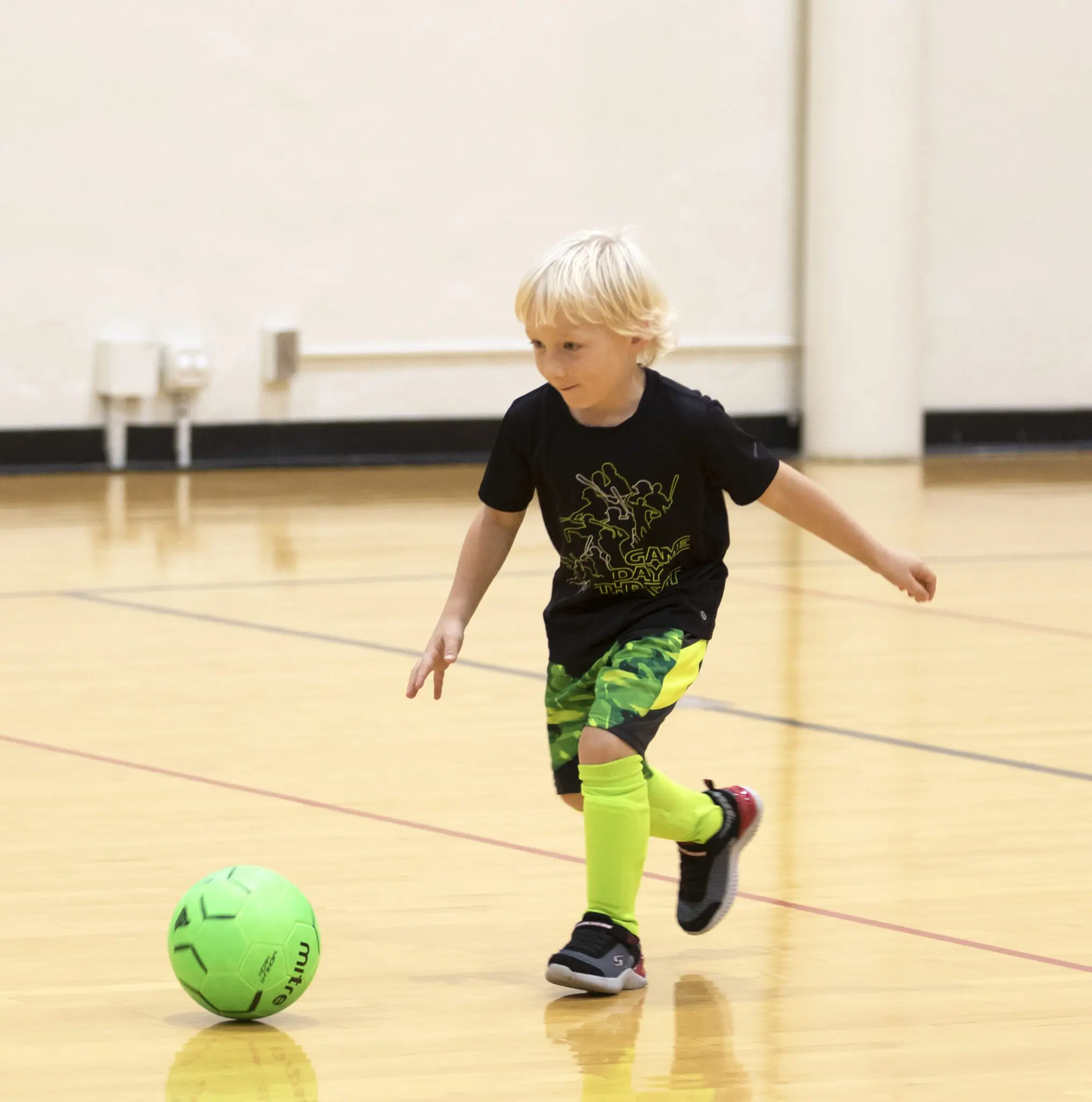 youth boy playing soccer indoors