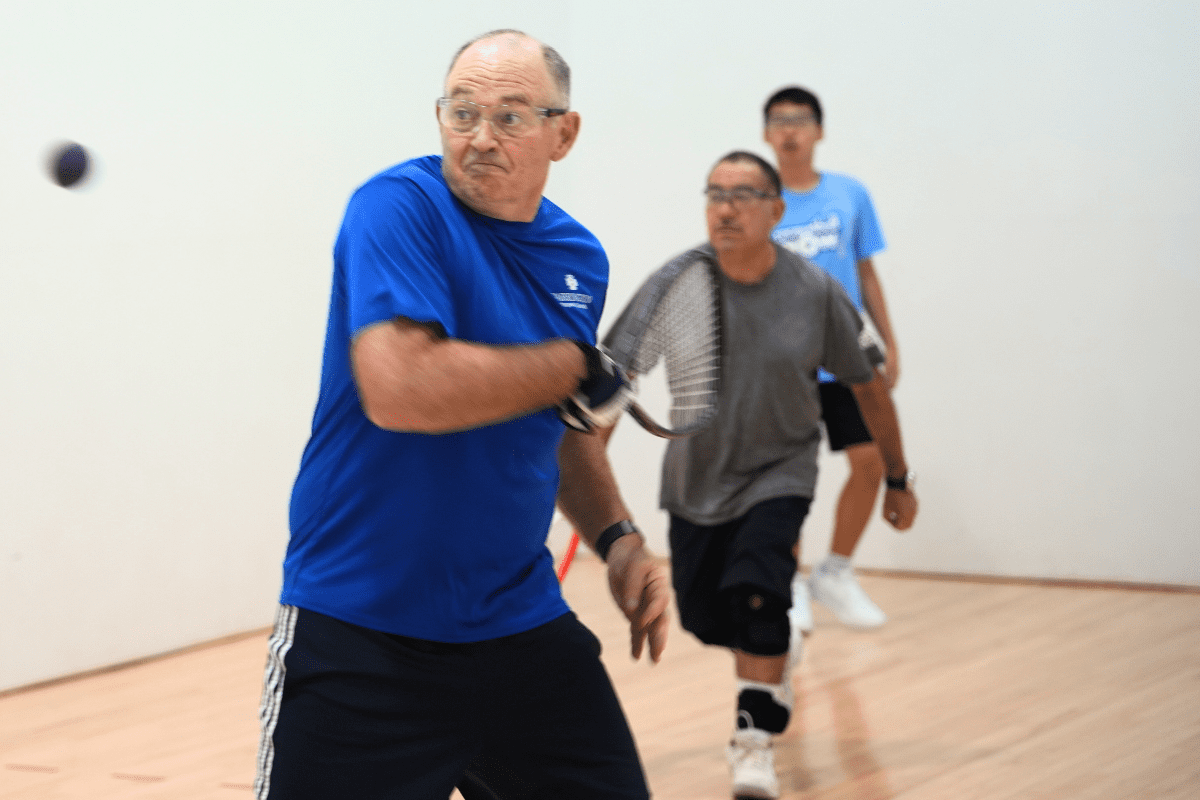 3 men playing raquetball